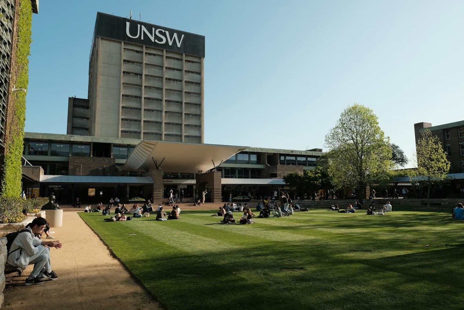 Students relaxing on a sunny lawn between classes at an Australian university